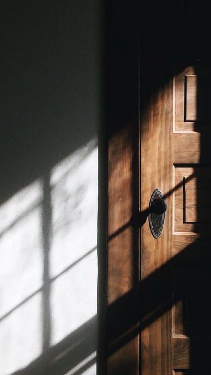 Porte en bois avec lumière naturelle créant des ombres géométriques